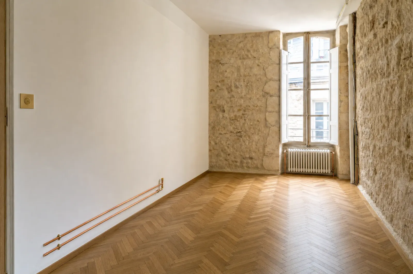La pièce finie : le radiateur en fonte, le parquet poncé